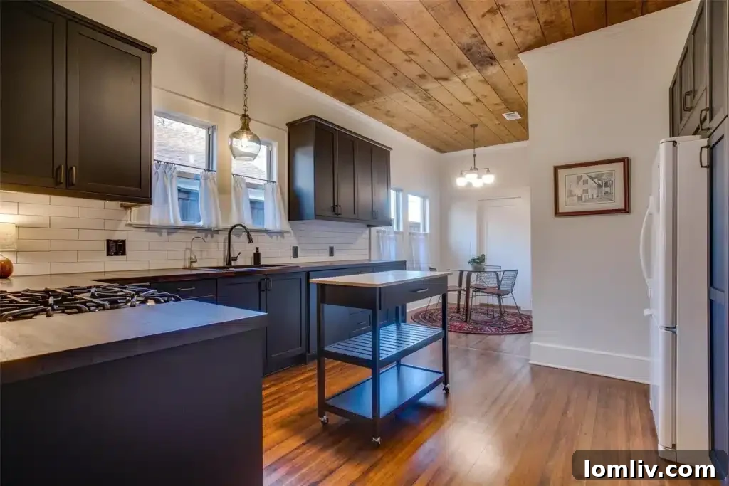 Modern kitchen with black cabinets, brass hardware, and exposed brick
