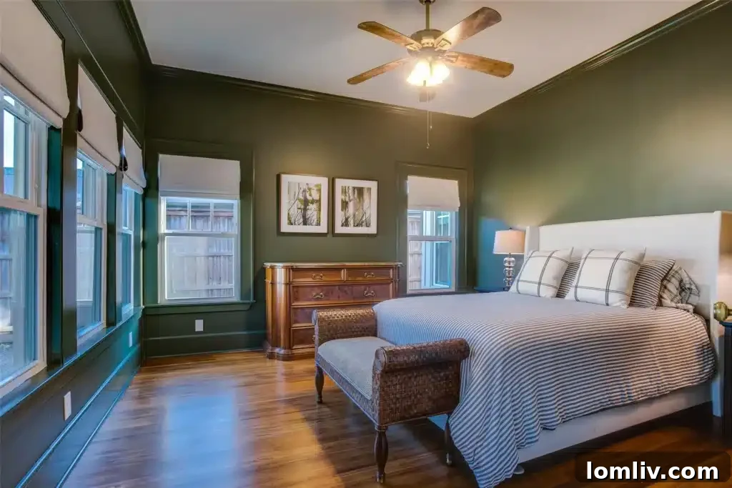 Cozy guest bedroom with Hunter Green walls, large windows, and natural light