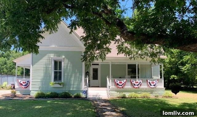 A charming, historic Victorian home in Grandview, Texas, with a welcoming front porch, suggesting a journey back in time.