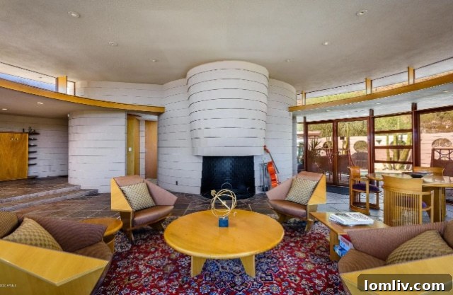 Elegant circular dining area with modern table and chairs, offering desert views in the Frank Lloyd Wright home