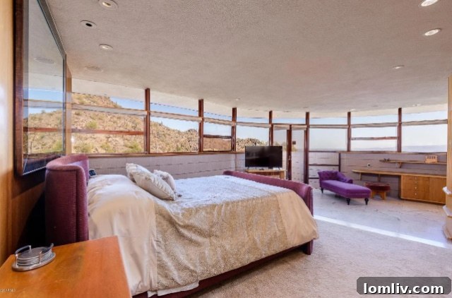 Bedroom featuring golden-hued Philippine mahogany walls and expansive windows with sweeping desert views