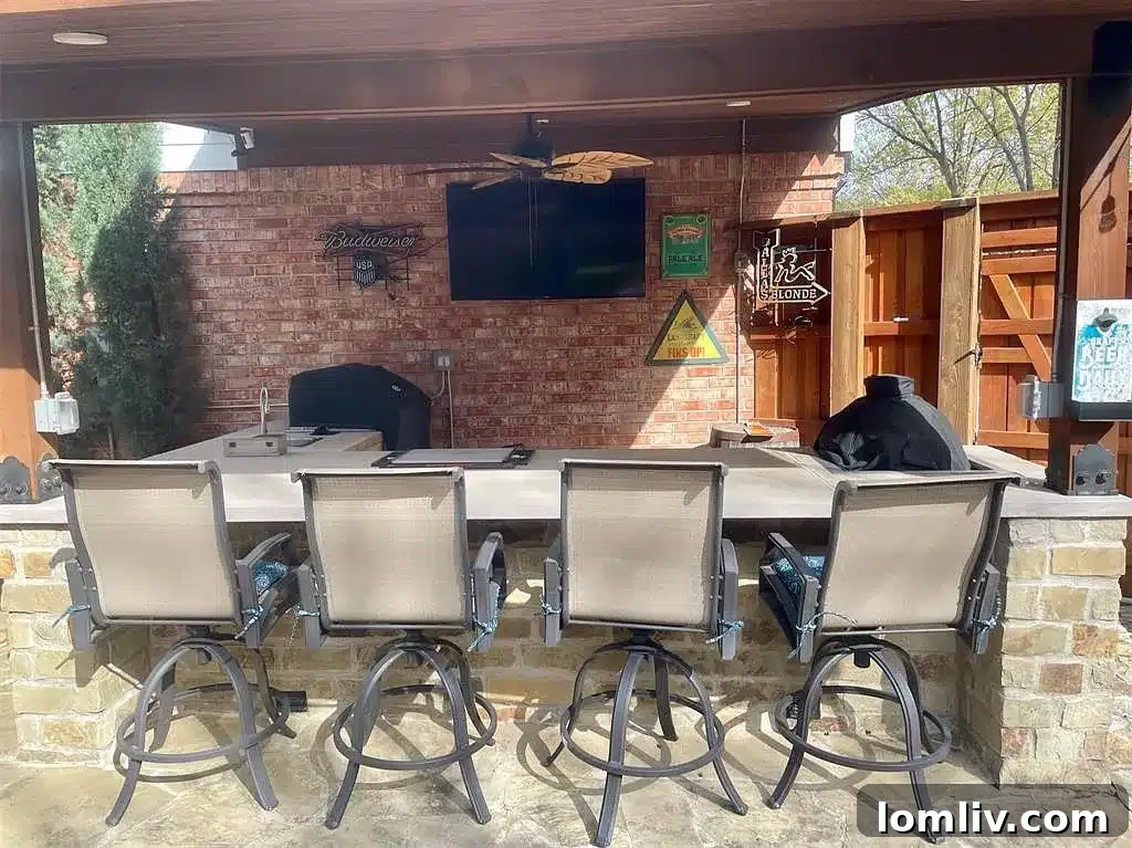 Outdoor bar area with a built-in grill and TV for entertainment in Grapevine
