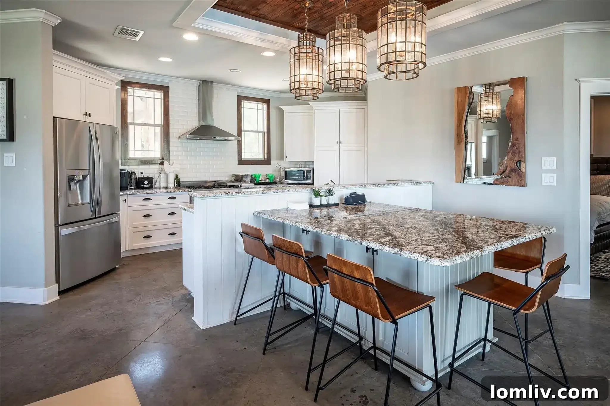 Modern kitchen in the guest house with high-end appliances, granite countertops, and a central island with pendant lighting and a breakfast bar.
