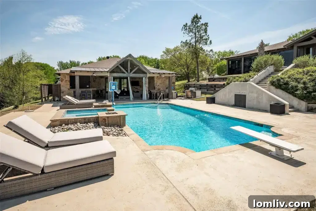 Stunning renovated pool and spa area at 218 Hunter Pass, surrounded by ample lounging space and lush landscaping, with the lake visible in the background.