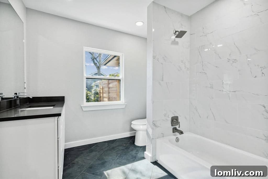 Luxurious primary bathroom with white slate flooring and renovated shower