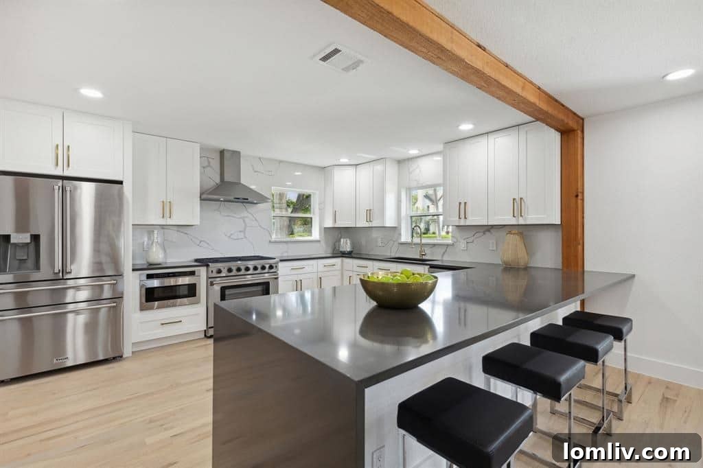 Luxury kitchen featuring quartz waterfall island and stainless steel appliances