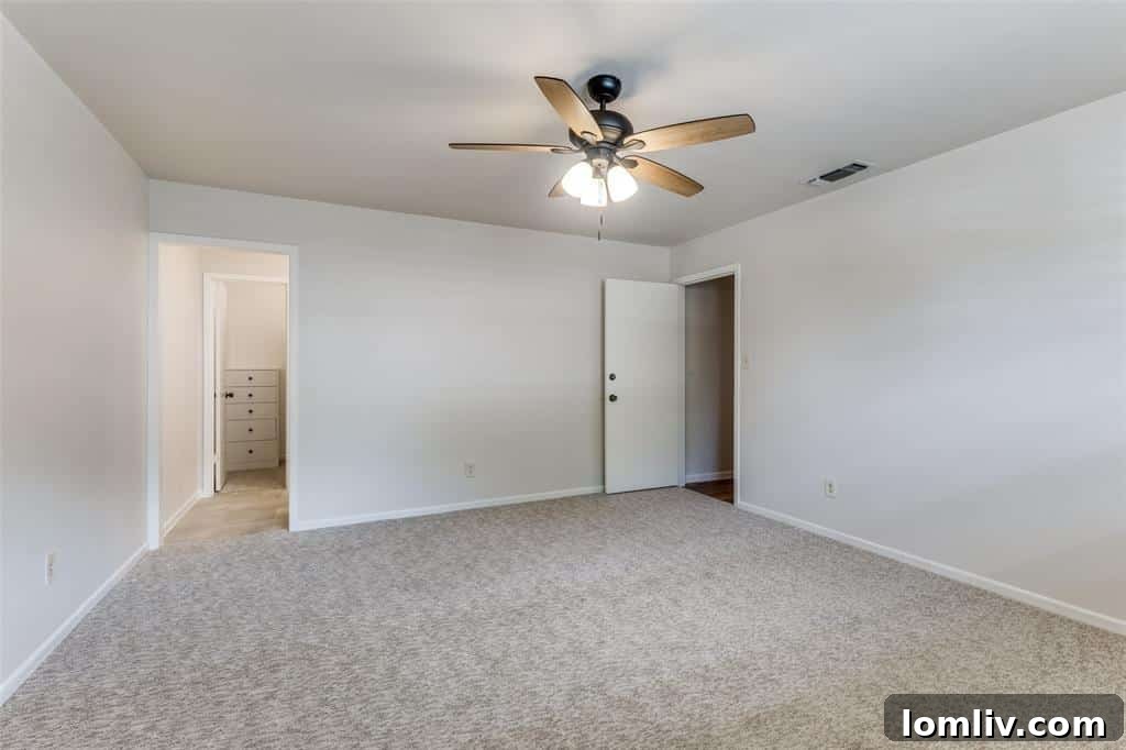 Bright and spacious bedroom with bi-fold closets in a Fort Worth duplex, featuring designer white finishes.