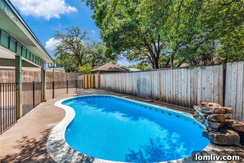 Invigorating inground pool and lush mature trees in the backyard of the Fort Worth duplex at 4705 Ranch View Road.