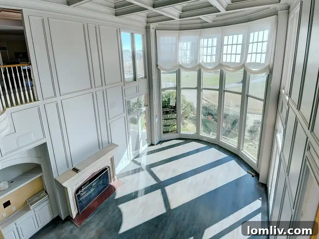 Opulent living room with ornate fireplace, custom built-ins, and direct access to outdoor living spaces.