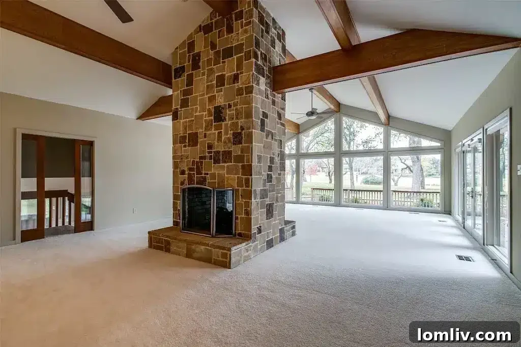 Spacious living room with large windows overlooking a golf course, featuring modern furniture and warm lighting.