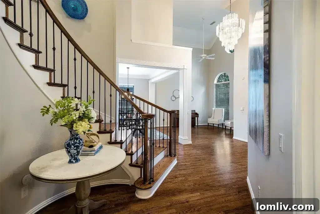 Grand two-story entryway in the Frisco home, featuring an elegant staircase and abundant natural light, creating a welcoming and sophisticated ambiance.
