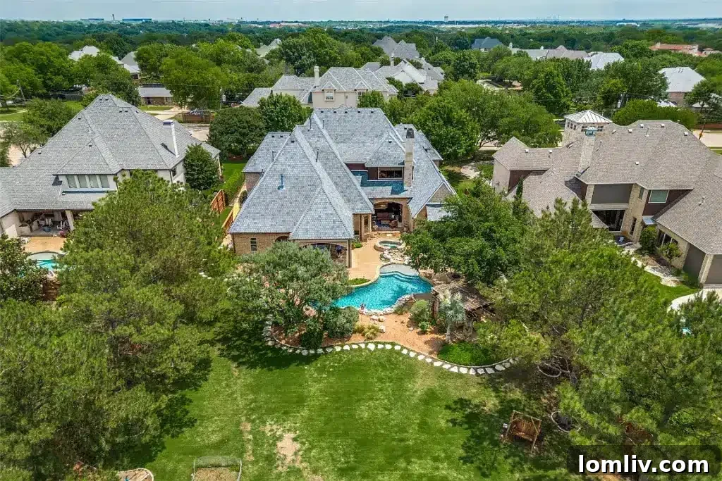 Luxurious backyard of a Colleyville home, showcasing a stunning swimming pool with natural stone accents and lush landscaping, creating a private resort ambiance.