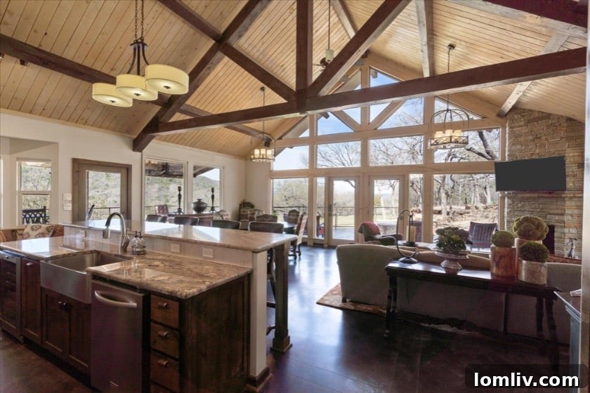 Interior view of the living room with high ceilings, fireplace, and large windows overlooking the natural scenery.