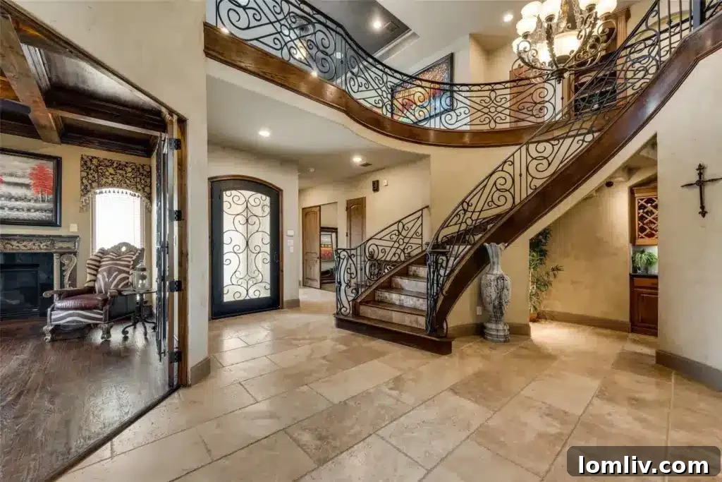 Dramatic grand staircase making an impressive statement in the luxurious foyer of a McKinney home.