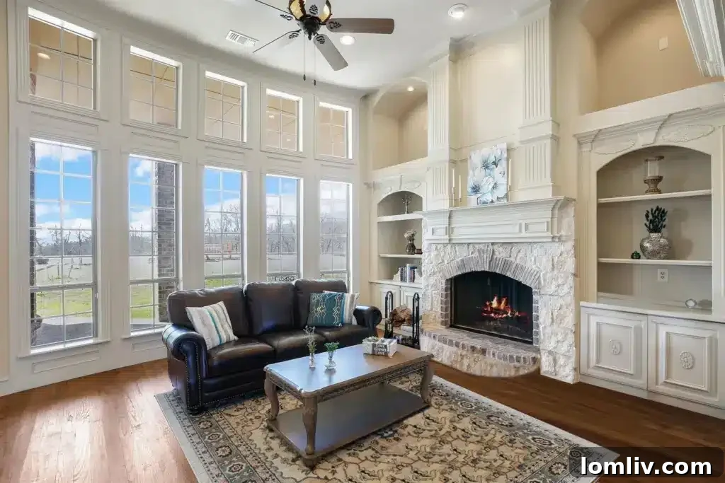 Living area with large windows flooding the space with light and a cozy fireplace, in a McKinney home.