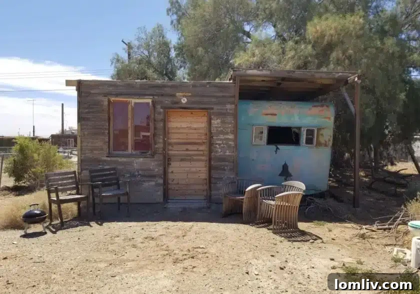Fenced outdoor area with a grill and commode, providing functional space for desert living in Bombay Beach.
