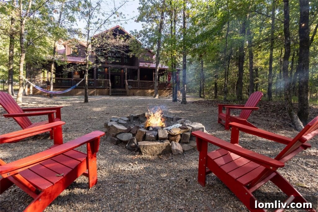 Outdoor patio on a wrap-around porch with a gas fireplace, hot tub, and comfortable seating, ideal for relaxation in a luxury cabin