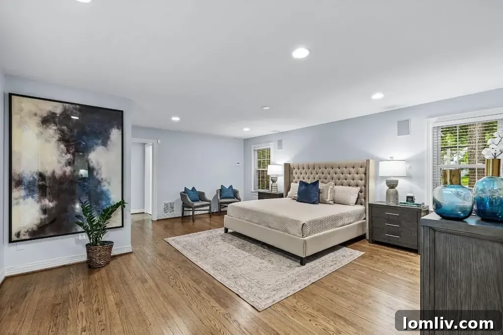 Spacious and serene primary bedroom with large windows and muted tones.