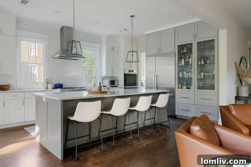 Modern kitchen with an eat-in island, high-end appliances, and elegant fixtures