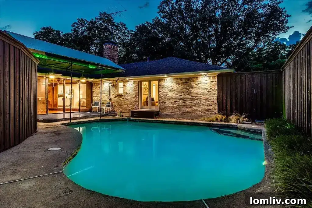 Inviting backyard with a sparkling in-ground swimming pool, lush landscaping, and spacious patio