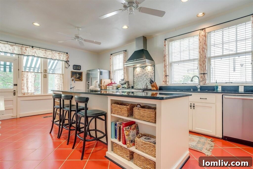 Spacious kitchen with large island, bar seating, and unique tomato-colored tile floors