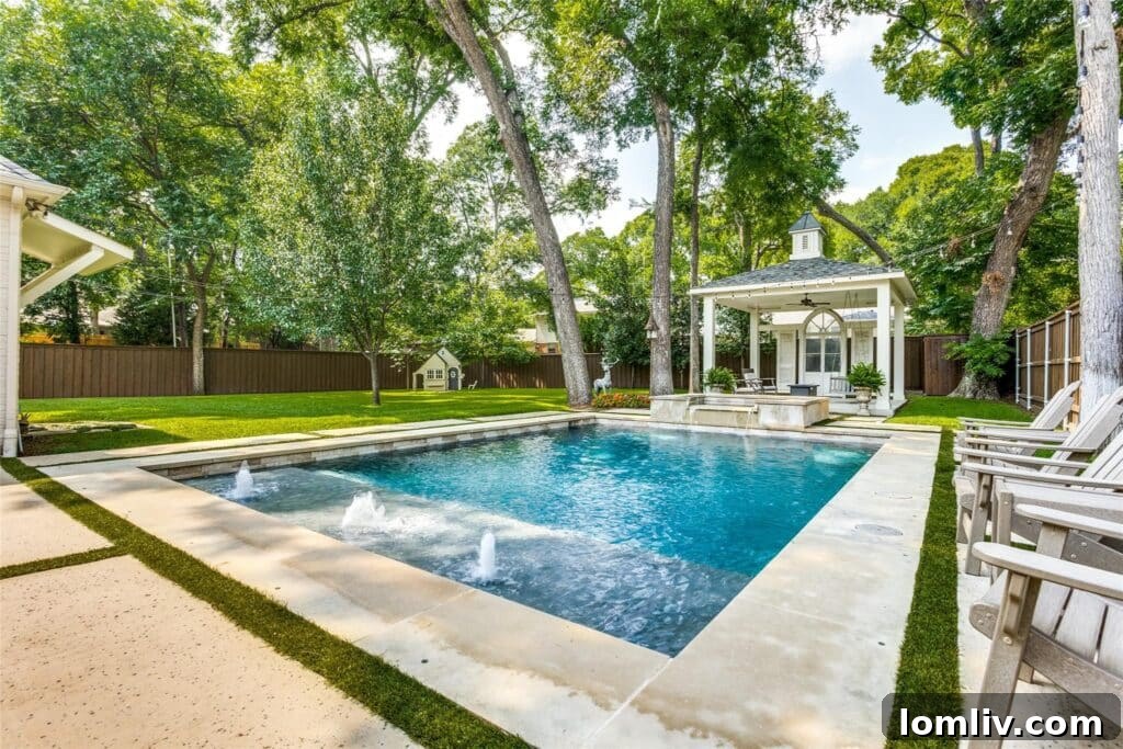 Resort-style swimming pool with spa and lush landscaping