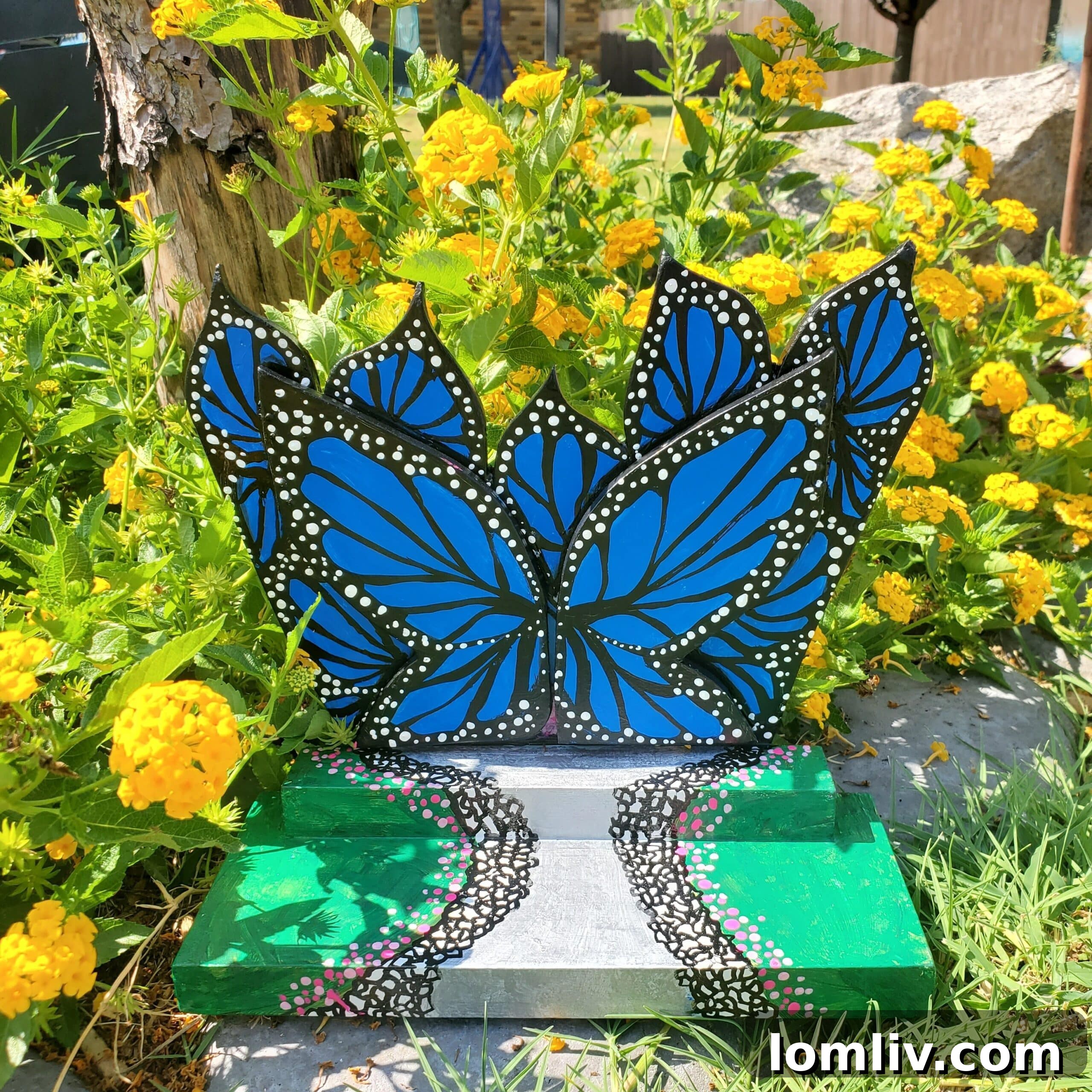 Artist Juju's hand-painted, intricate tiny door featuring a detailed butterfly on a vibrant bloom, inviting viewers into a miniature world.