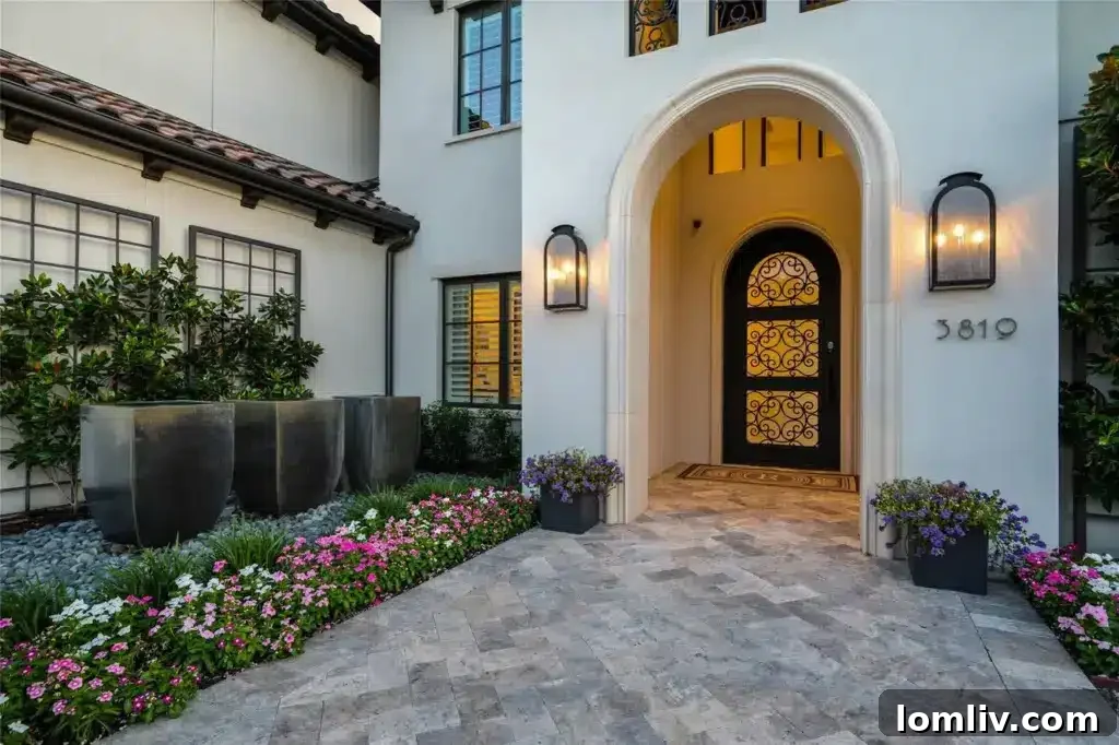 Front exterior of a grand modern Mediterranean estate in Frisco, featuring elegant architecture, lush landscaping, and a welcoming entrance.