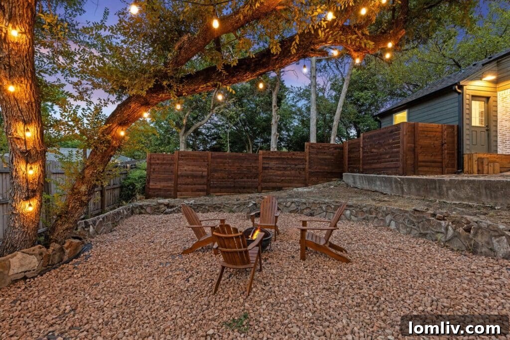 The expansive and beautifully landscaped backyard of the Oak Cliff house, featuring a stunning wooden deck with a modern grid railing, perfect for outdoor entertainment.