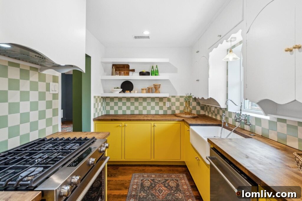A cheerful and modern kitchen in the Oak Cliff home, featuring sunny yellow cabinets, a muted green and white patterned backsplash, and a sleek custom-vented range hood.