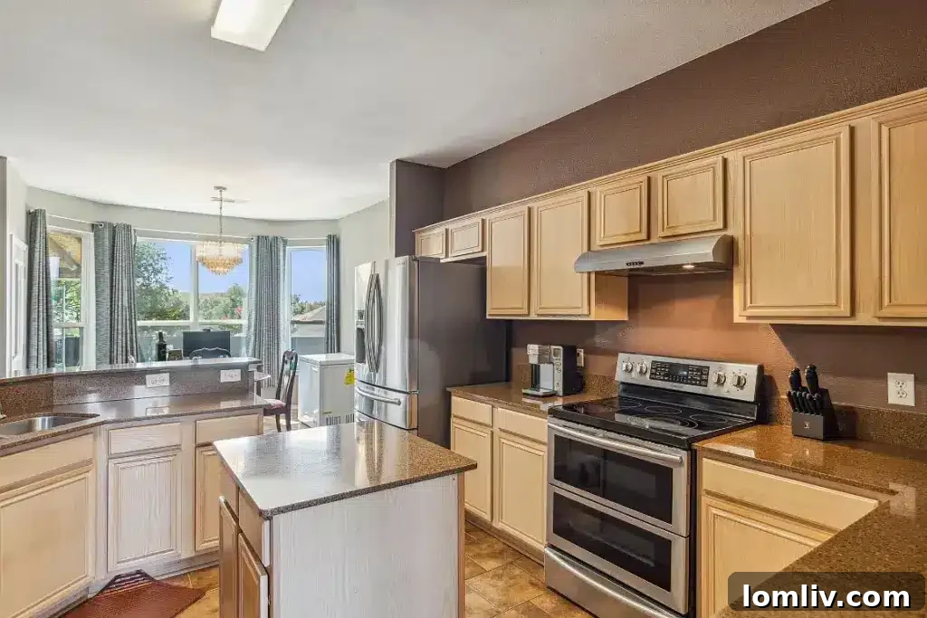 Modern kitchen with updated appliances, extensive counter space, and a breakfast bar, perfect for everyday meals.
