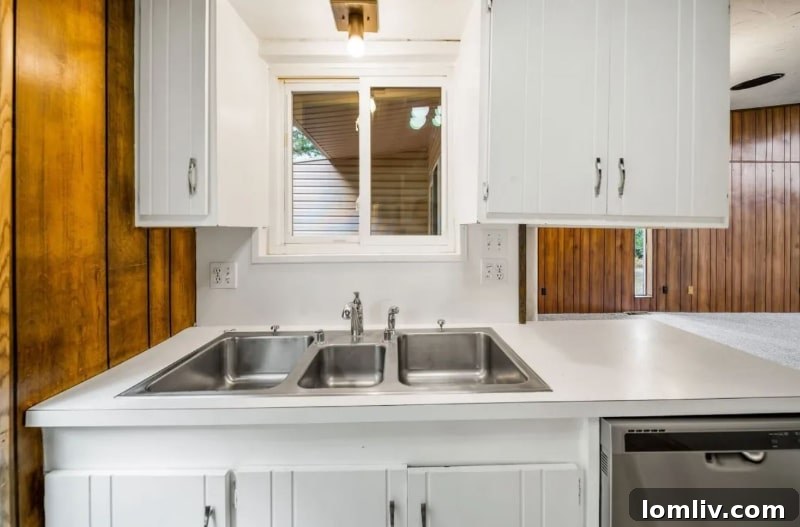 An intriguing view of the kitchen in the Oklahoma City home, with a peculiar window placement and dated appliances.