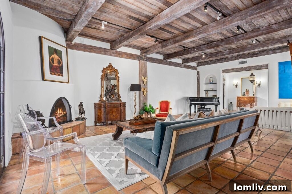 The impressive Sala (living room) with its timber-beamed ceiling and Saltillo tiled floor, a hallmark of Spanish Colonial design.