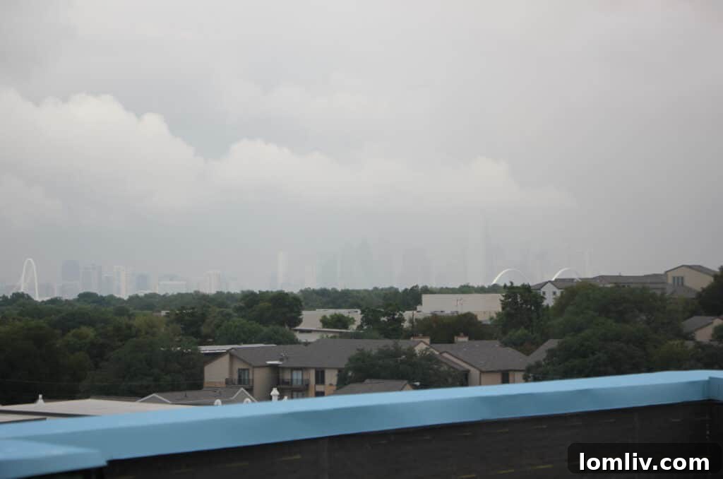 Dallas skyline partially obscured by clouds and rain