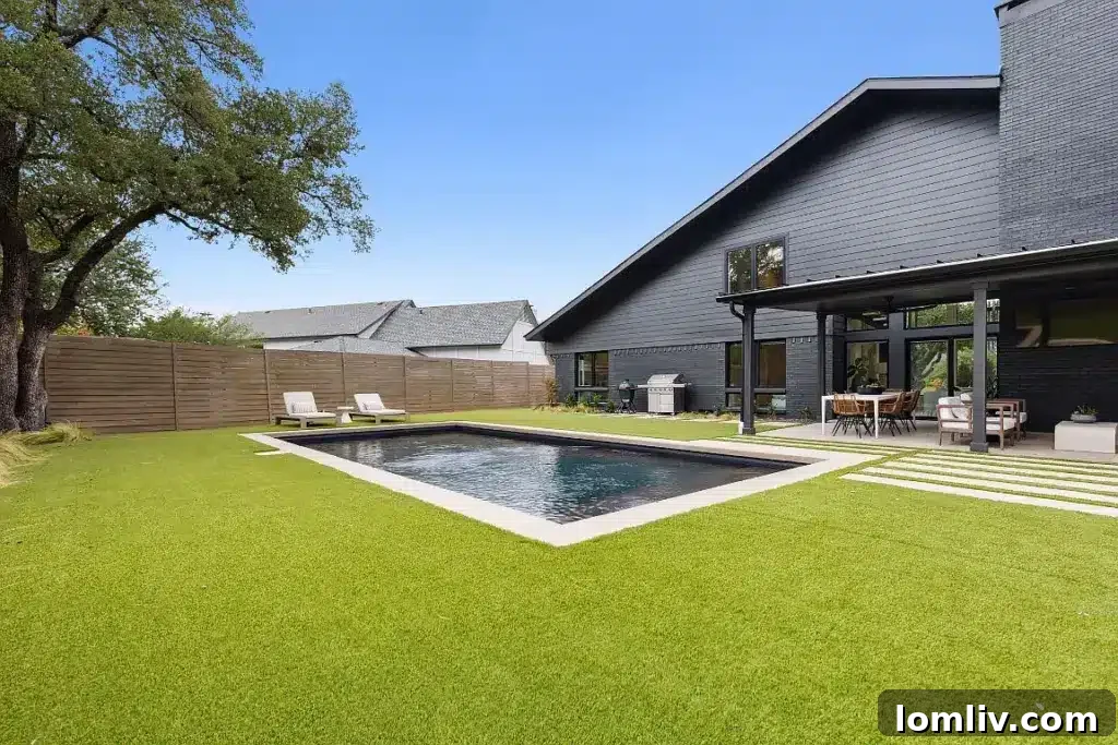 Heated infinity saltwater pool and covered patio in the Midcentury Modern backyard oasis.
