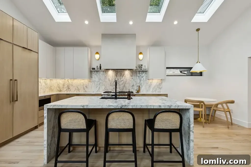 Gourmet kitchen with waterfall marble island and high-end Wolf appliances.