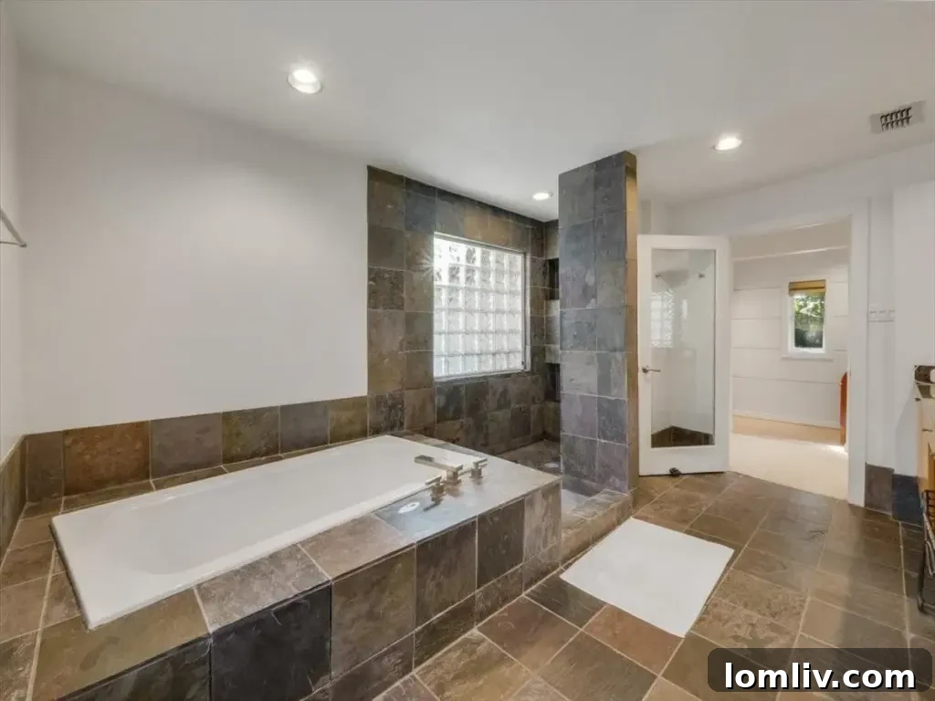 Spacious primary bedroom featuring elegant French doors that open directly onto a private covered patio, offering a secluded retreat.