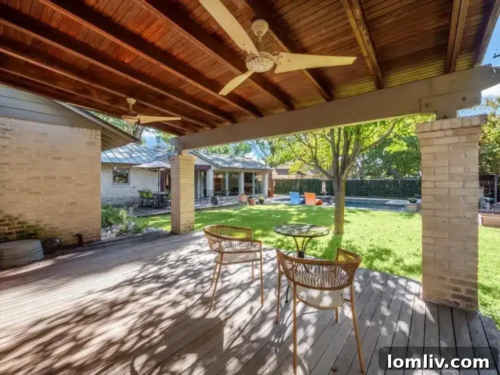 Inviting saltwater pool in the lush backyard, surrounded by shady trees and ample space for outdoor entertaining.