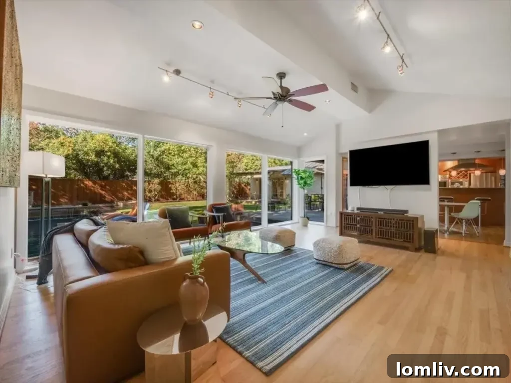 Elegant formal living room featuring gleaming hardwood floors and abundant natural light, ideal for sophisticated entertaining.