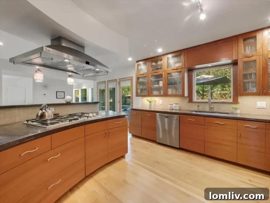 Stunning kitchen featuring custom African Makore wood cabinetry, sleek concrete countertops, and stainless steel appliances.