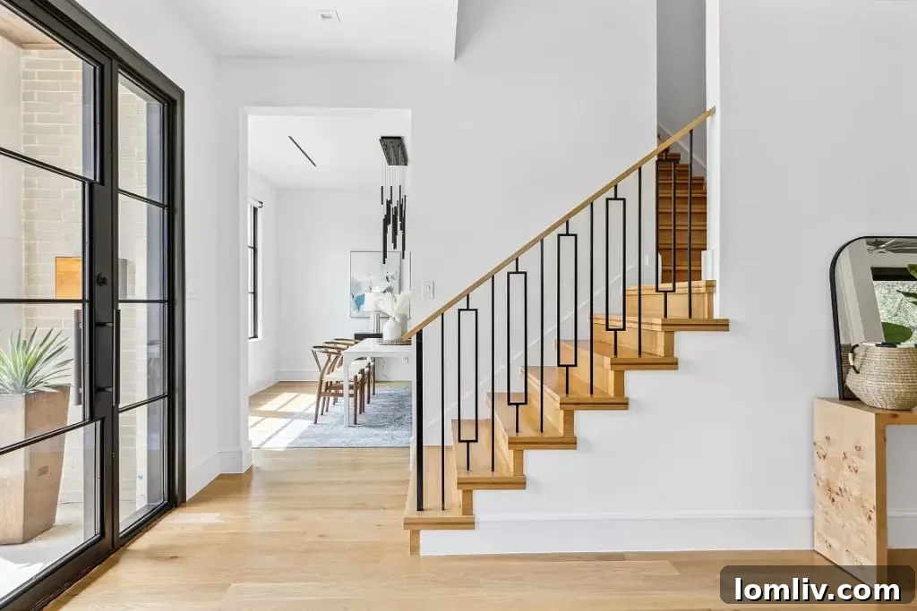 Ridgecrest Village: A Modern Masterpiece 4 An inviting foyer of a luxury Dallas home, showcasing clean lines, designer lighting, and sleek interior finishes.