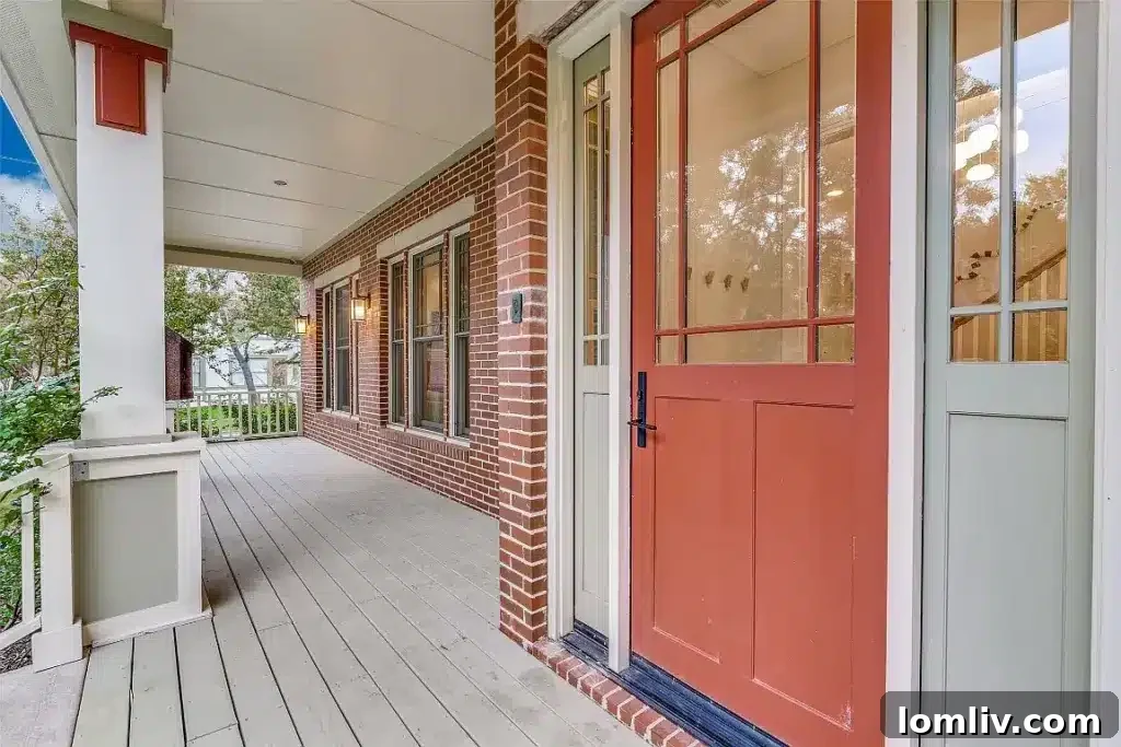 Front exterior of a Dallas Prairie Style home with a wraparound porch and stone facade