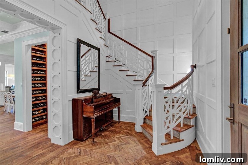 Grand entryway of Midway Hills Modern Tudor with chevron hardwood floors and paneled walls