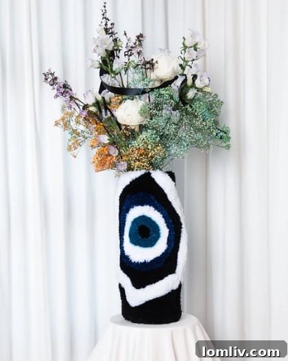 A unique, hand-tufted decorative vase shaped like an eye, displaying intricate texture