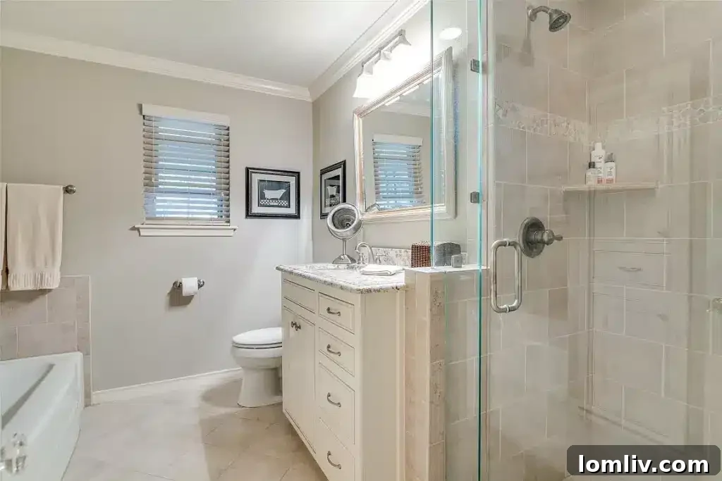 Luxurious primary bathroom featuring a spacious frameless glass walk-in shower and elegant custom vanity.