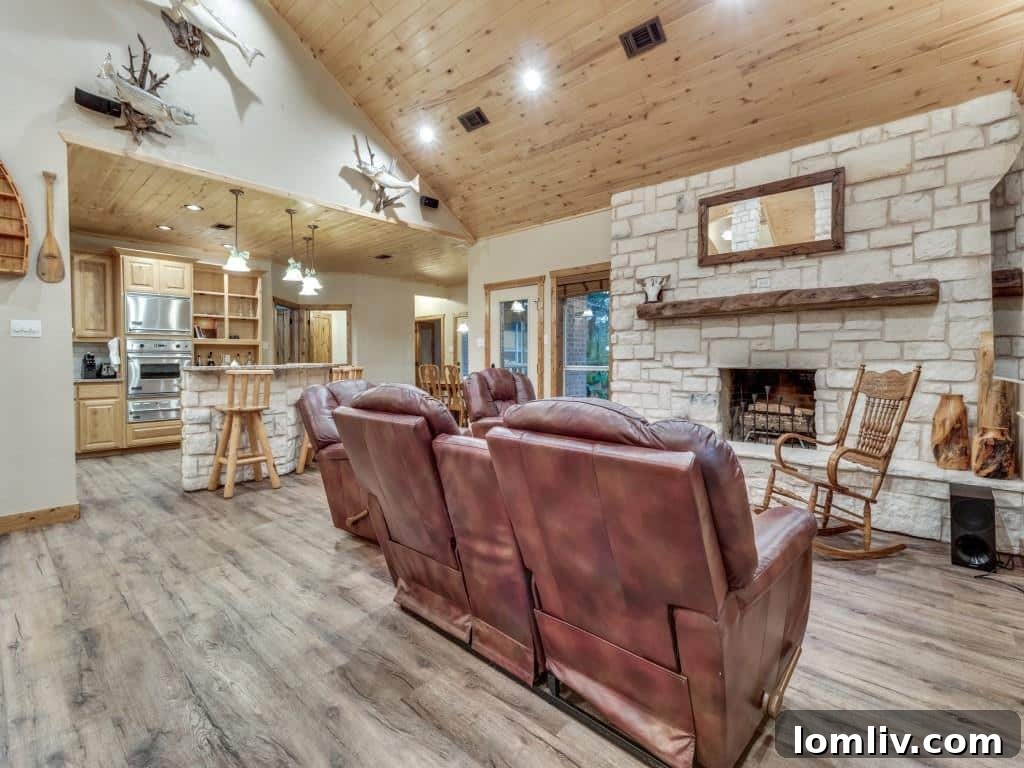 Interior view of the spacious and inviting great room, featuring soaring vaulted ceilings, elegant wooden beams, and a magnificent Blanco stone fireplace.