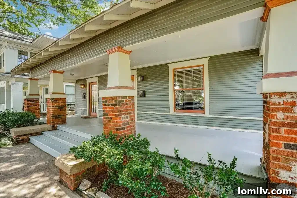 Front exterior of a charming Craftsman duplex in Dallas, featuring a welcoming porch and classic brick columns.