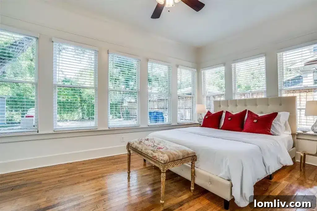 Another view of a spacious bedroom with a bed, classic decor, and natural light.