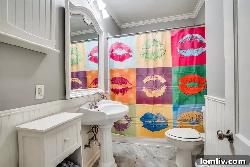 Elegantly designed bathroom with a pedestal sink, shiplap walls, and classic fixtures.