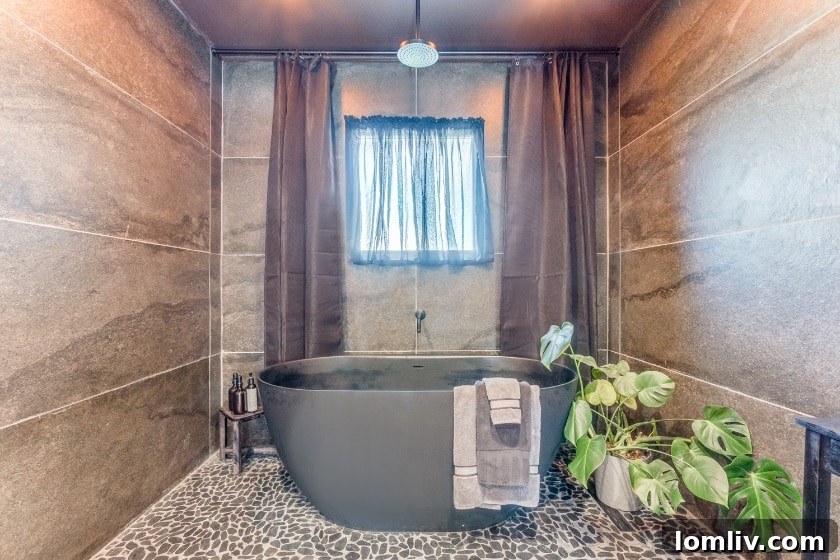 The primary bathroom's striking stone accent wall provides a focal point, complemented by subtle lighting.